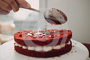 Pastry chef makes delicious red velvet cake. Cooking and decorating dessert
