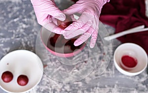 The pastry chef prepares dessert on a stick with a cake of red velvet with milk chocolate