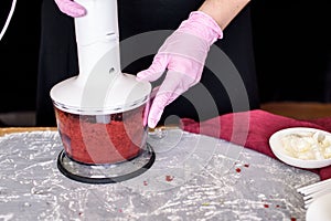 The pastry chef prepares dessert on a stick with a cake of red velvet with milk chocolate