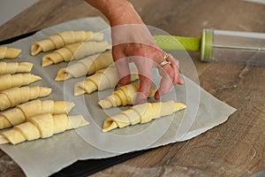 A pastry chef is preparing pastries in the kitchen. Croissants before baking. . Cooking process. Step by step. 1