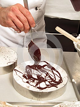 Pastry chef preparing vanila chocolate cake.