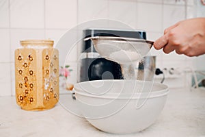 Pastry chef sift pours flour makes cake. Cooking and preparing dessert