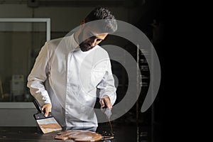 Pastry chef working on tempering chocolate on marble table