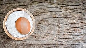 Pastry flour on bowl and rustic wooden background / homemade flour egg cooking ingredients on table