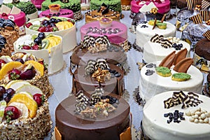 Pastry shop with selection of cream or fruit cake. Colorful beautiful cakes displayed on the marble countertop