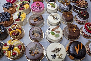 Pastry shop with selection of cream or fruit cake. Colorful beautiful cakes displayed on the marble countertop
