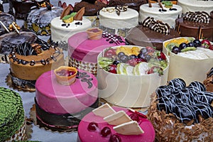 Pastry shop with selection of cream or fruit cake. Colorful beautiful cakes displayed on the marble countertop