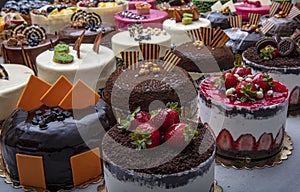 Pastry shop with selection of cream or fruit cake. Colorful beautiful cakes displayed on the marble countertop
