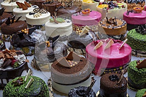 Pastry shop with selection of cream or fruit cake. Colorful beautiful cakes displayed on the marble countertop