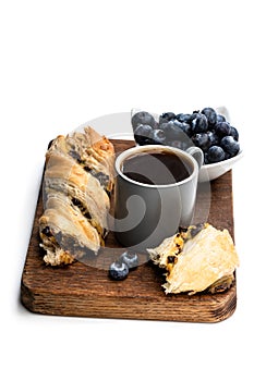 Pastry twist with blueberry and cup of coffee isolated on white