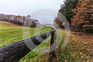 Pasture fence and fallen leaves in autumn