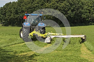 Pasture mowing with blue tractor