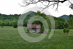 Pasture view with barn, truck, and mountains