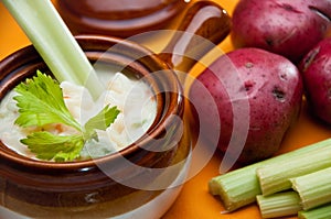 Patatoe soup in crock with celery spoon photo
