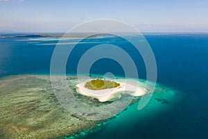 Patawan island. Small tropical island with white sandy beach. Beautiful island on the atoll, view from above