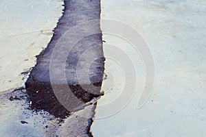 Patch of new asphalt in the old broken road