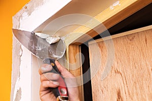 Patching plaster around a new door with spatula