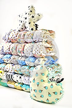 Patchwork and fashion concept - beautiful stack of colorful quilts, bedspreads stacked in several rows in height for storage