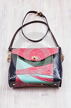 Patchwork leather evening bag on gray table