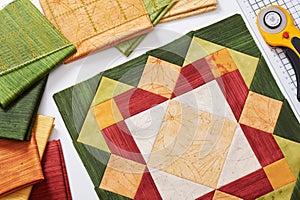 Patchwork orange-green block, quilting fabrics, sewing accessories