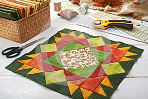 Patchwork orange-green block, quilting fabrics, sewing accessories photo