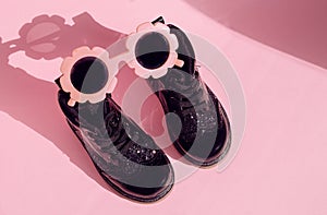 Patent children`s boots shoes and accessories for little fashionistas on a pink background photo