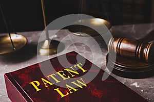 Patent Law book and gavel on grey marble table, closeup