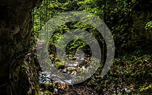 Path through big rock, river and cave