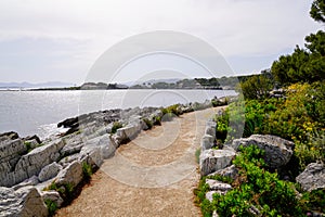 Path on the coast beach walk to rock beach coast Juan-les-Pins in Antibes France