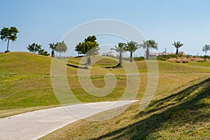 Path going through golf course in Spain with clear blue sky