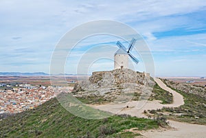 A path and a hill with old white windmill at a viewpoint near Consuegra