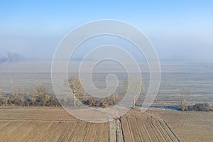 A path in the middle of fields in the mist in Europe, in France, in the Center region, in the Loiret, towards Orleans, in Winter,