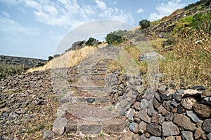 A path with stairs in ruins of the ancient Jewish city of Gamla on the Golan Heights destroyed by the armies of the Roman Empire i