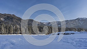 The path is trodden in a snow-covered valley between snowdrifts.