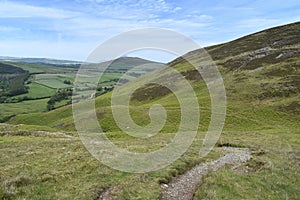 Path winding on hillside with fields below