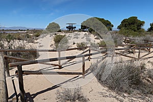 Path with wooden balas towards the Pinet observatory tower on the dune route of Salinas del Pinet, La Marina, Alicante, Spain photo