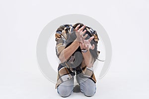 A pathetic and fearful young asian man bowing down and begging to be spared. Isolated on a white background