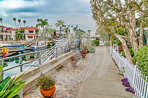 Pathway along a canal with docks and leisure boats in Long Beach California