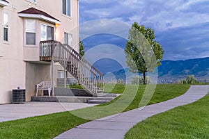 Pathway in front of a home with stairs leading to the second floor entrance