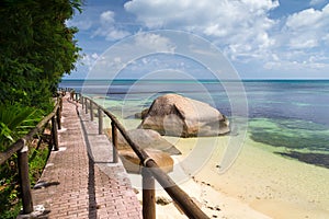 Pathway by the ocean with big stones and green plants