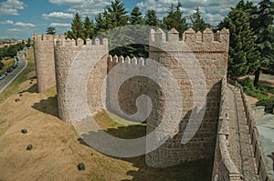Pathway over old thick wall with large towers in Avila