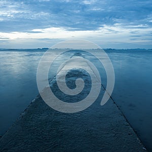 Pathway receding over blue sea