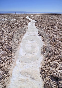 Pathway among Salar de Atacama, the Chilean Salt Flat in Northern Chile with Silhouette of Visitors in Afar