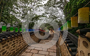 Pathway steps to Korean Buddhistic Temple Beomeosa with many lanterns to celebrate buddhas birthday on a foggy day. Located in