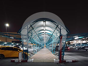 pathway structure of roof curve blue color in the mall parking during the night