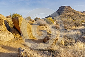 Pathway surrounded by hills, rocks and dry grass