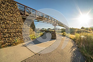 Pathway trail and bridge against blazing sun and clear blue sky background