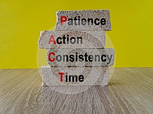 Patience action consistency time symbol. Concept words PACT patience action consistency time on brick blocks