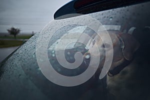 Patience dog waiting in car during heavy rain photo