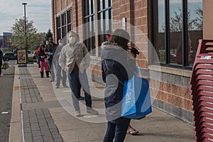 Covid-19, crowd wearing face masks wait in line to enter food market, suburban Philadelphia, PA, April 11, 2020